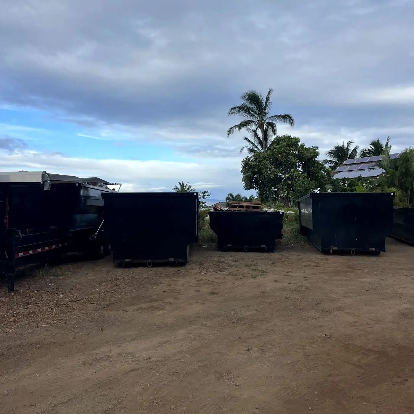 A row of Hawaii Hauling roll-off bins in the yard